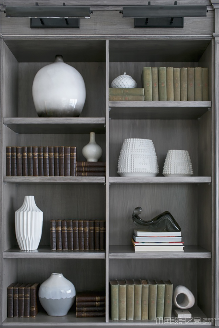 Interior designer Karen B. Wolf uses several vase silhouettes to break up the mo<em></em>notony of bound volumes.