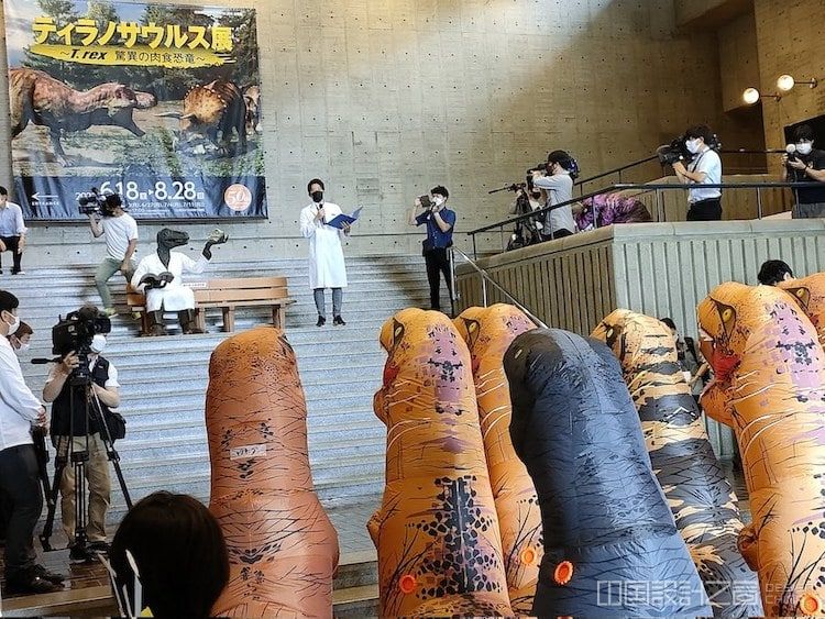 T-Rex Exhibition With Attendees Wearing Dinosaur Costumes