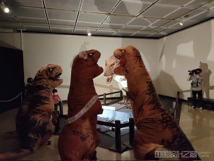 T-Rex Exhibition With Attendees Wearing Dinosaur Costumes