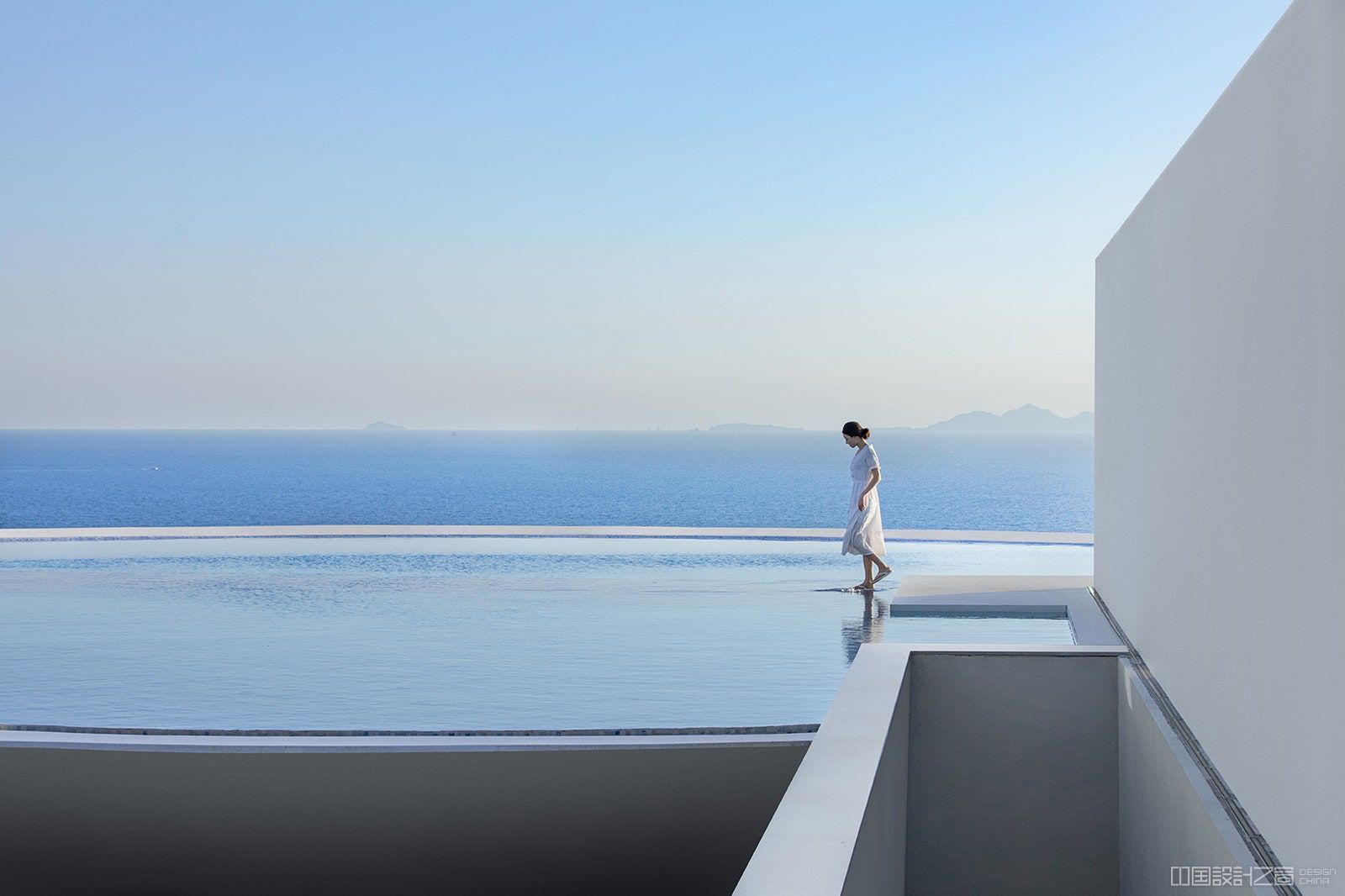 Woman walks on stepping sto<em></em>nes through the rooftop pool