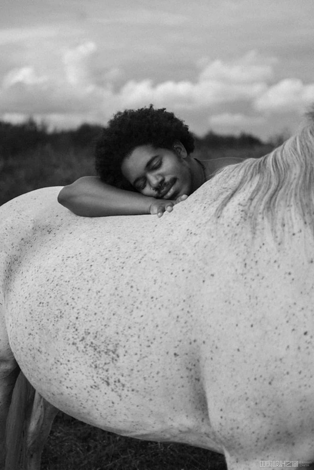 Black and White Photo of a Man Resting His Head on a Horse