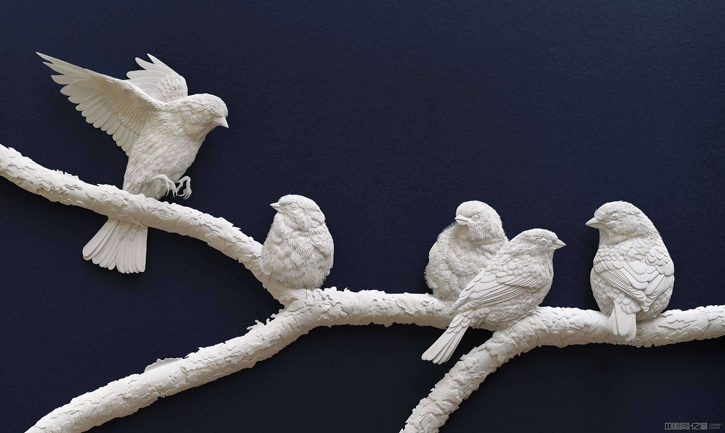 A sculpture of birds on a branch made from paper.